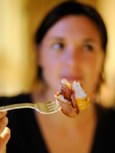 Woman holding fork with food on it